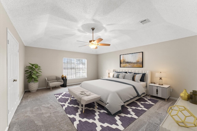 bedroom with a ceiling fan, baseboards, visible vents, carpet floors, and a textured ceiling