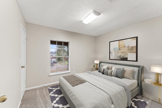 carpeted bedroom with baseboards and a textured ceiling