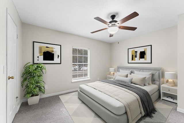 bedroom with ceiling fan, baseboards, and light carpet