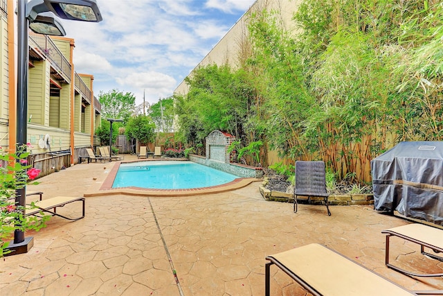 view of swimming pool featuring a fenced backyard, area for grilling, a fenced in pool, and a patio