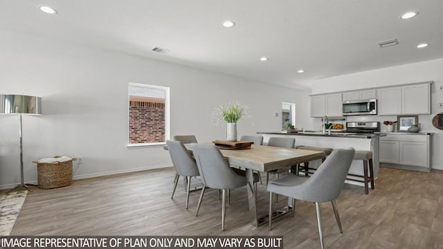 dining area featuring light wood finished floors, visible vents, and recessed lighting