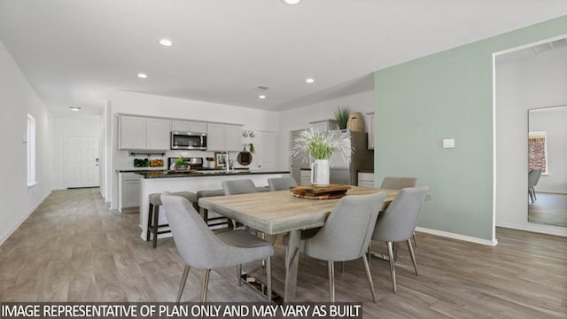 dining area featuring light wood-style floors, baseboards, and recessed lighting