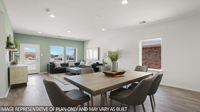 dining room with baseboards, wood finished floors, and recessed lighting