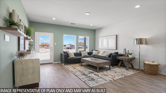 living room with wood finished floors, visible vents, and recessed lighting