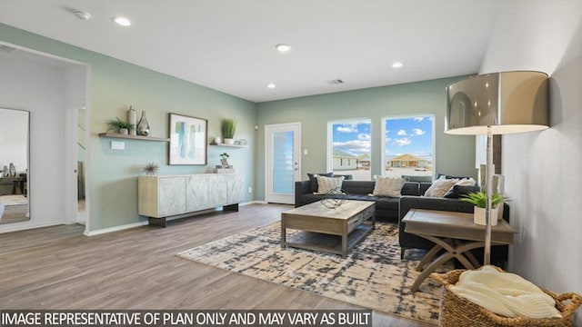 living room with visible vents, baseboards, wood finished floors, and recessed lighting