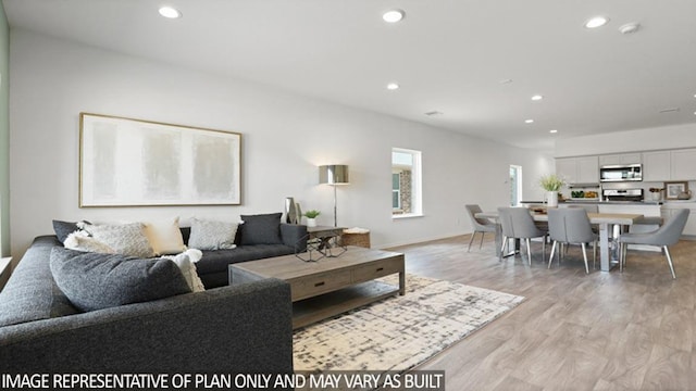 living area featuring baseboards, recessed lighting, and light wood-style floors