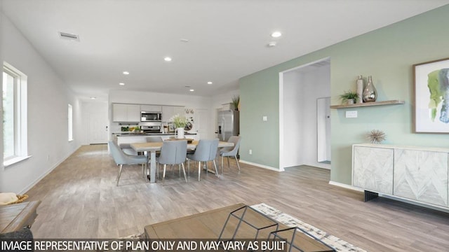 dining space with light wood-style flooring, visible vents, baseboards, and recessed lighting