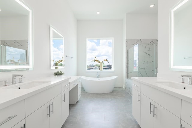 full bath with a freestanding tub, a marble finish shower, two vanities, and a sink