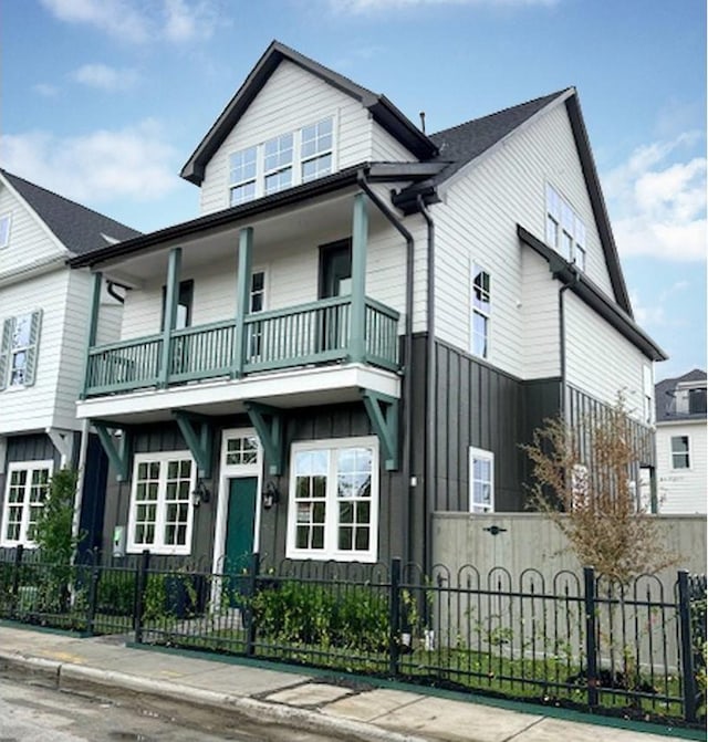 view of front of house with a fenced front yard and a balcony