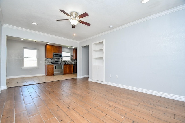 kitchen with brown cabinetry, light wood finished floors, appliances with stainless steel finishes, crown molding, and tasteful backsplash