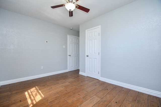 empty room with ceiling fan, baseboards, and hardwood / wood-style floors