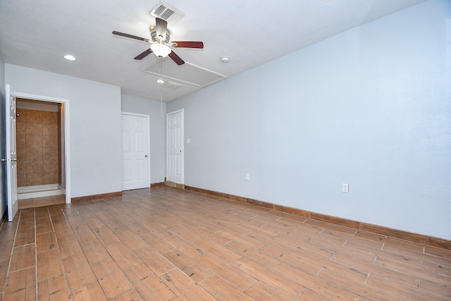 spare room featuring visible vents, baseboards, ceiling fan, attic access, and light wood-style flooring