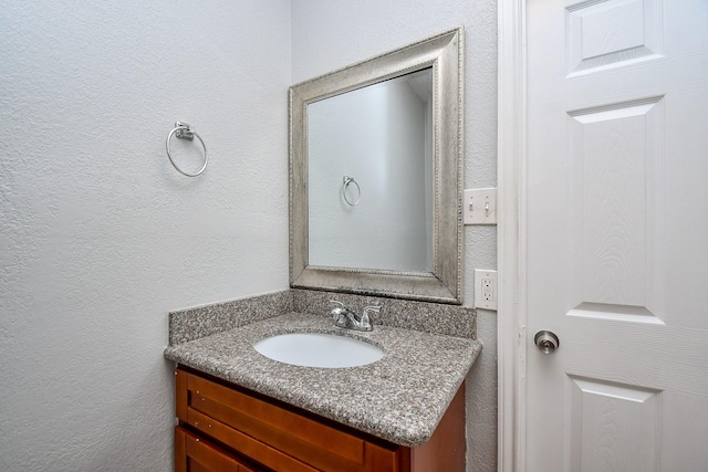 bathroom with vanity and a textured wall