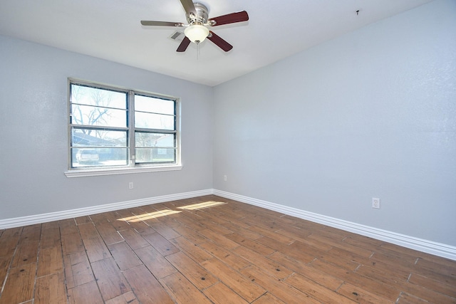 spare room featuring visible vents, ceiling fan, baseboards, and wood finished floors