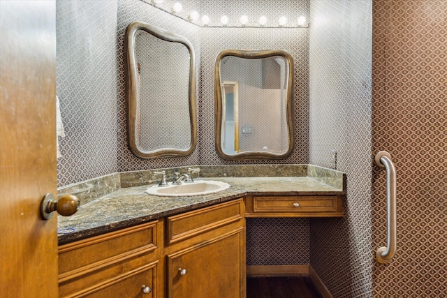 bathroom with vanity and wallpapered walls