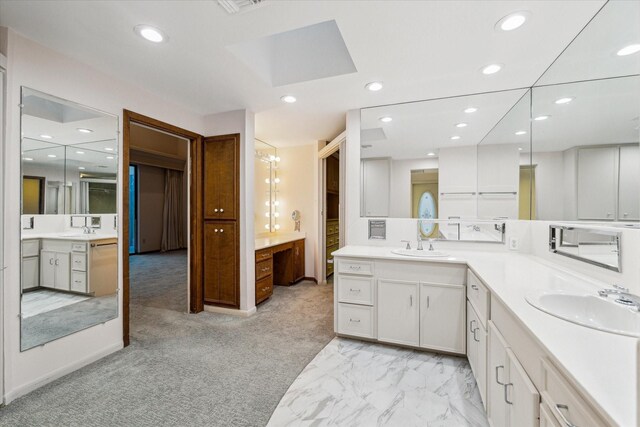 bathroom with marble finish floor, vanity, and recessed lighting