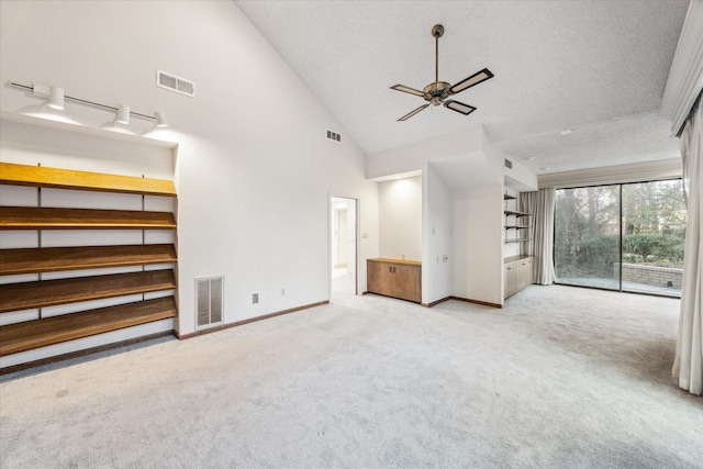 interior space featuring a textured ceiling, carpet, visible vents, and baseboards