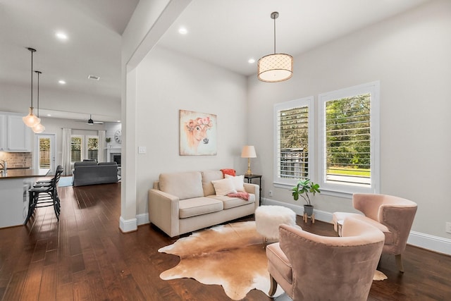 living area with dark wood finished floors, plenty of natural light, recessed lighting, and baseboards