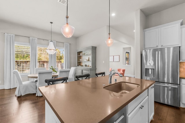 kitchen featuring dark wood-style floors, decorative light fixtures, stainless steel fridge with ice dispenser, and a sink