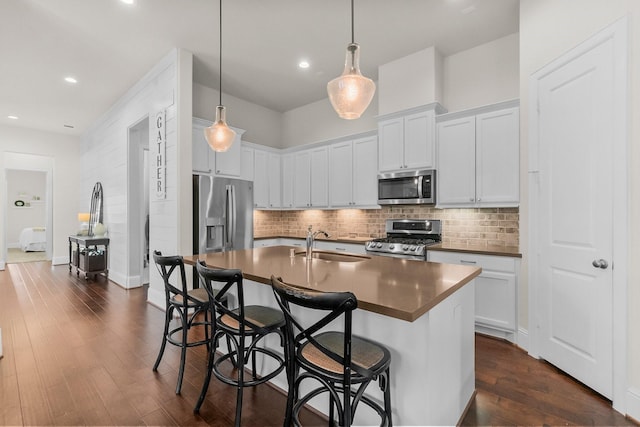 kitchen featuring a sink, decorative backsplash, dark wood finished floors, and stainless steel appliances