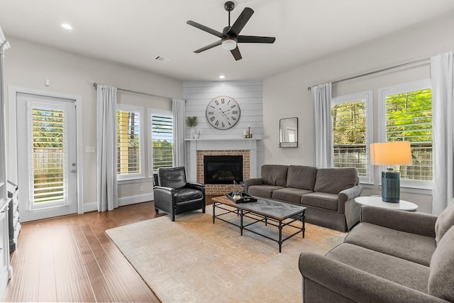 living room featuring visible vents, recessed lighting, a fireplace, and wood finished floors