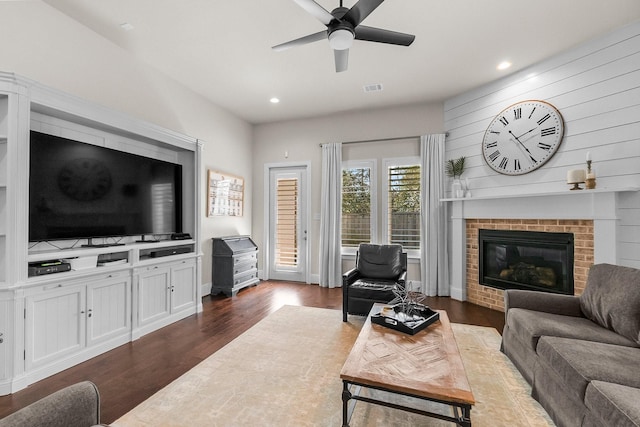 living area with visible vents, dark wood-type flooring, recessed lighting, a fireplace, and a ceiling fan