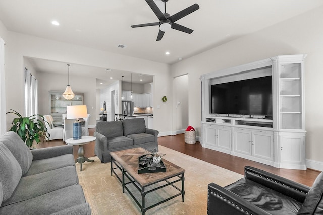 living room featuring recessed lighting, wood finished floors, visible vents, and baseboards