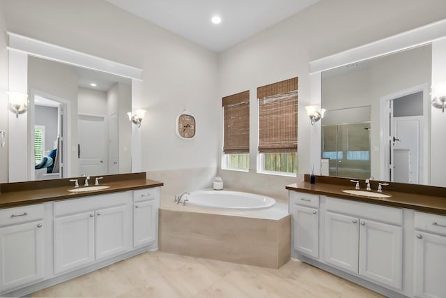 bathroom with a sink, two vanities, a bath, and a shower stall