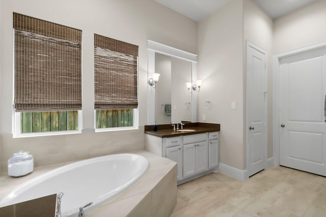 bathroom with vanity, a garden tub, and baseboards