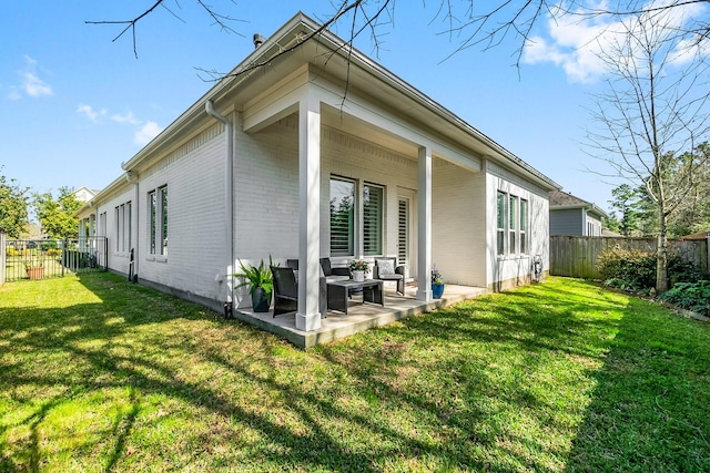 back of house with a patio, a fenced backyard, and a lawn