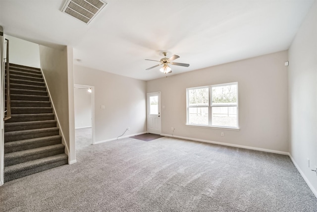 unfurnished room featuring a ceiling fan, visible vents, stairway, and baseboards