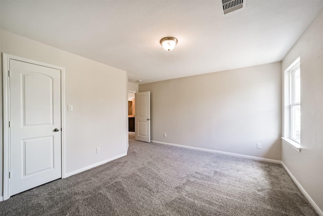 empty room with carpet, baseboards, and visible vents