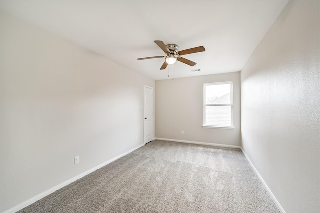 spare room with carpet, visible vents, ceiling fan, and baseboards