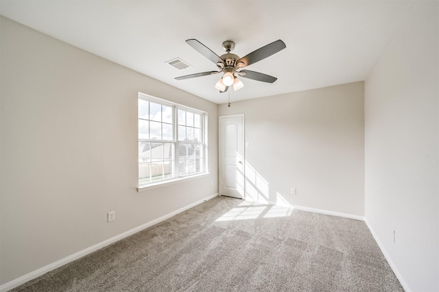 spare room with a ceiling fan, carpet flooring, visible vents, and baseboards