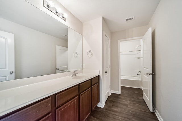 full bathroom with washtub / shower combination, baseboards, wood finished floors, and vanity