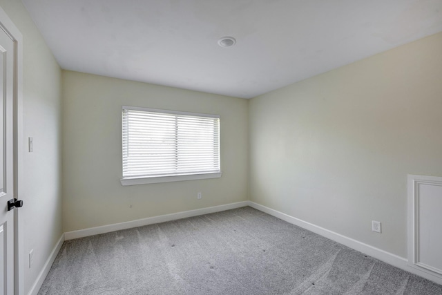 carpeted spare room featuring baseboards