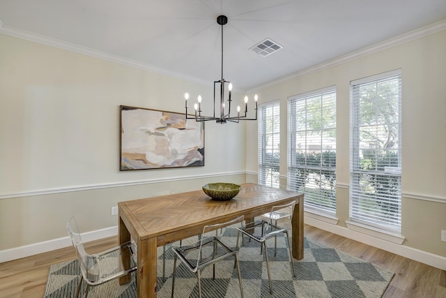 dining room with ornamental molding, visible vents, and wood finished floors