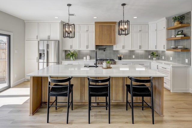 kitchen with visible vents, white cabinets, stainless steel fridge with ice dispenser, open shelves, and an inviting chandelier