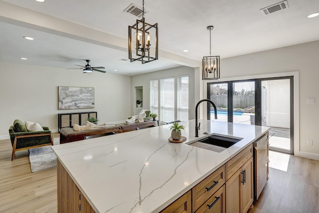 kitchen with visible vents, a sink, light wood finished floors, and stainless steel dishwasher