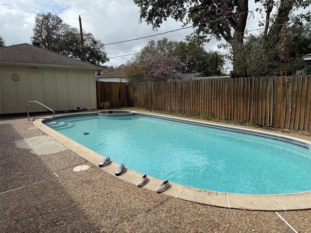 view of swimming pool with a patio area, a fenced backyard, and a pool with connected hot tub