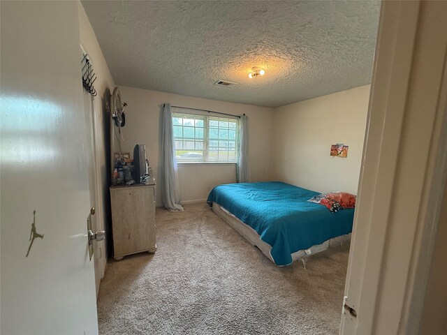 bedroom with light carpet, visible vents, and a textured ceiling