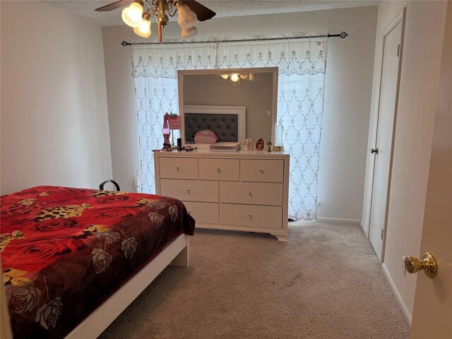 bedroom featuring light colored carpet, ceiling fan, a textured ceiling, and baseboards