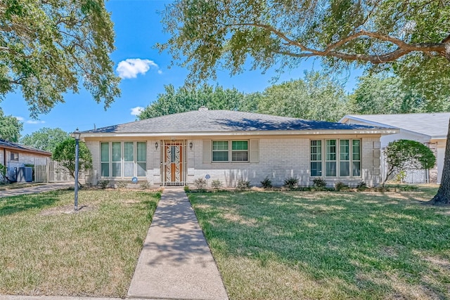 single story home with brick siding, a chimney, a shingled roof, a front yard, and fence