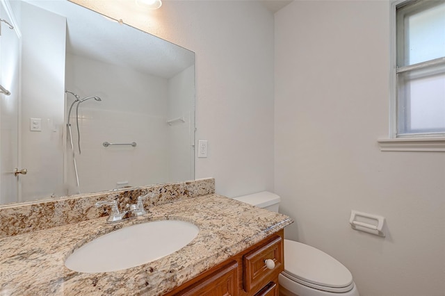 full bathroom with toilet, a shower, and vanity