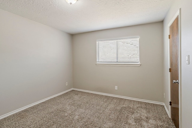 unfurnished room with a textured ceiling, carpet flooring, and baseboards