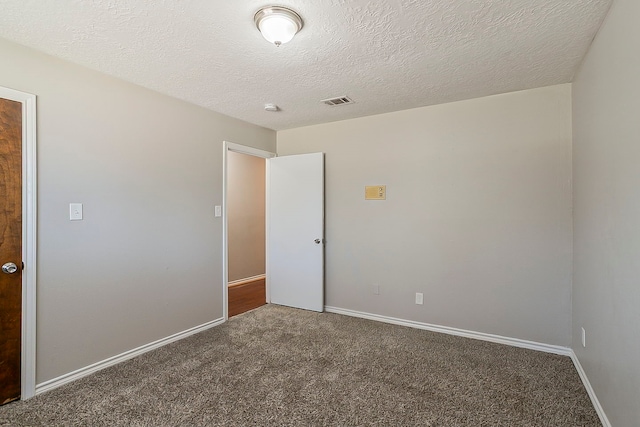 interior space with carpet floors, a textured ceiling, and baseboards