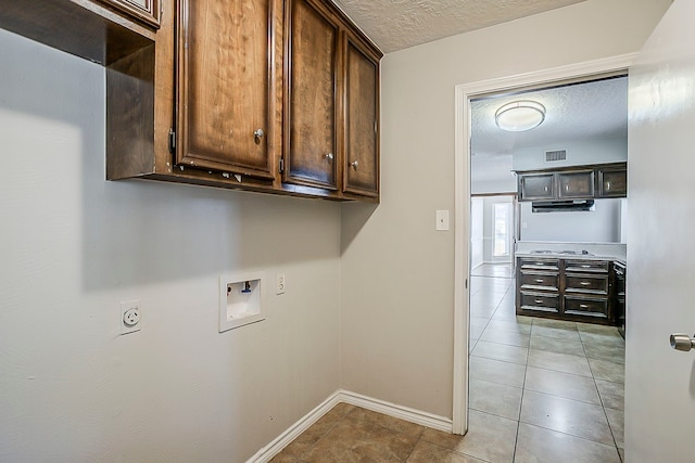 laundry room with washer hookup, cabinet space, visible vents, a textured ceiling, and baseboards