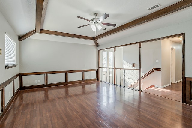 unfurnished room with a ceiling fan, visible vents, wood finished floors, and beamed ceiling