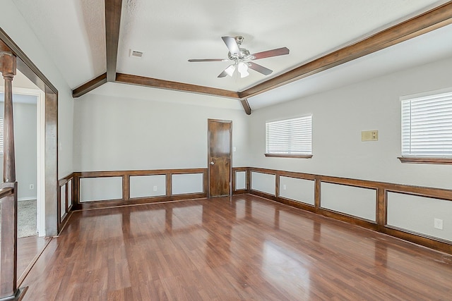 unfurnished room featuring ceiling fan, wood finished floors, visible vents, and lofted ceiling