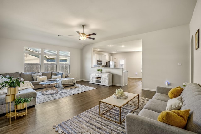 living room with dark wood-type flooring, a ceiling fan, baseboards, and visible vents